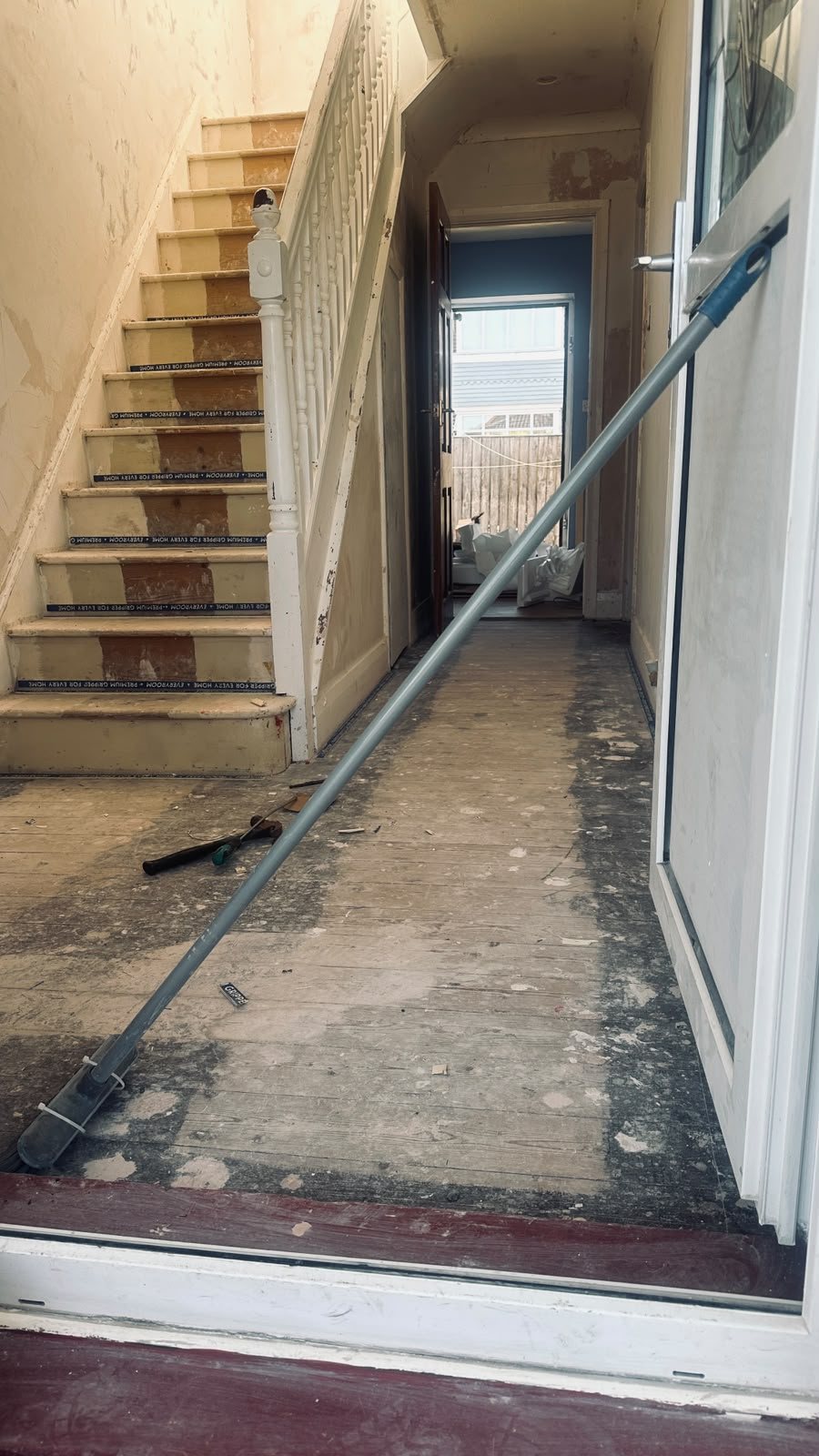 Room stripped back during renovation with ladder and tools on the bare floor